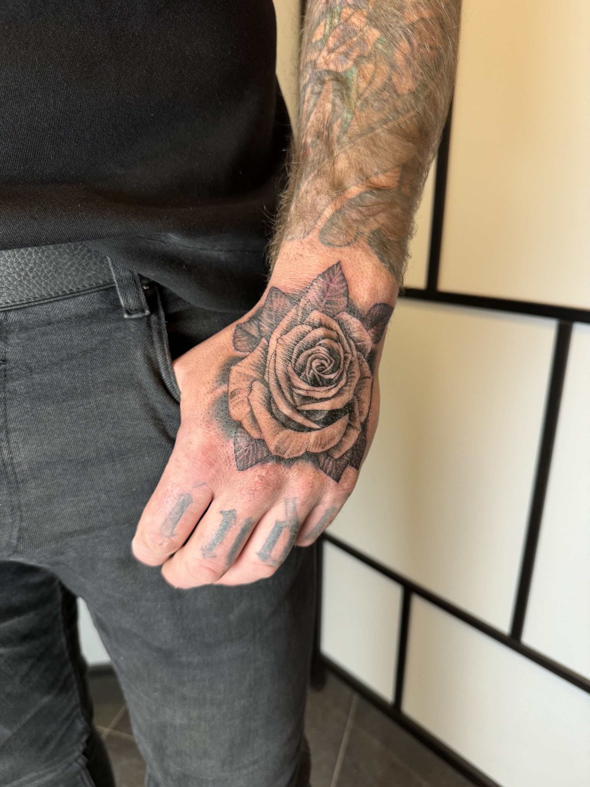 Hand met een getatoeëerde roos