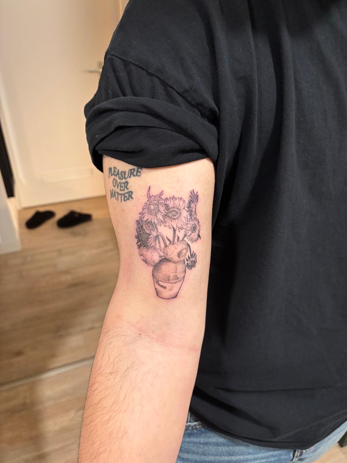 Bovenarm met een klein portret omringd door bloemen
